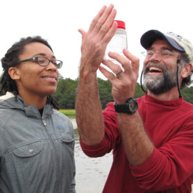 Professor Paul Bartels and student inspect a jar of water