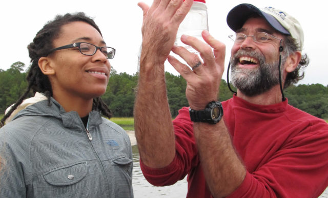 Professor Paul Bartels and student inspect a jar of water