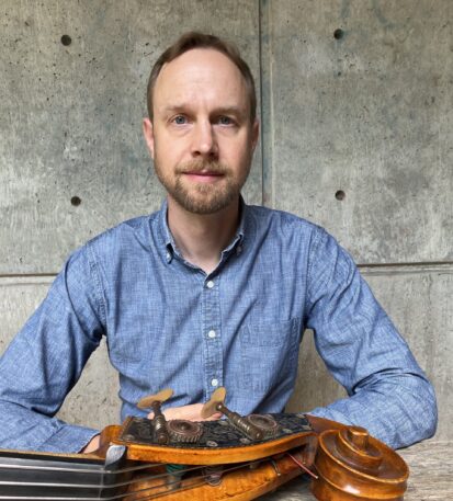 Faculty Member Kevin Kehrberg sits behind a instrument outside of Kitteridge.