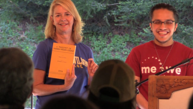 Senior Melvis Madrigal Nava gives Dr. Lynn Morton a copy of âA history of Warren Wilson College,â which was written by former dean Henry Jensen. 