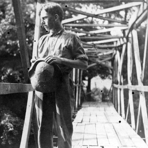 Archival photo of Asheville Farm School boy on a bridge