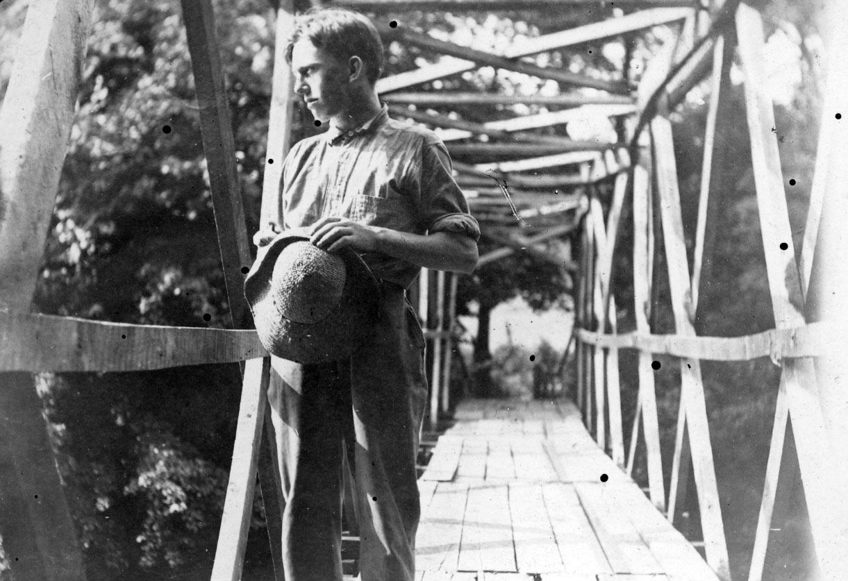 Archival photo of Asheville Farm School boy on a bridge