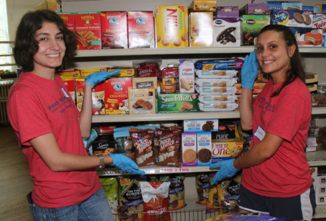 Tayla Clark â18, left, and incoming transfer student Emma Noel clean and restock shelves at Loving Food Resources in Asheville. 