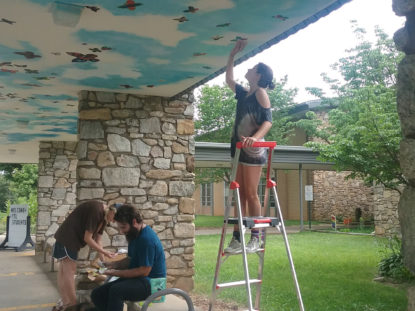 student painting mural