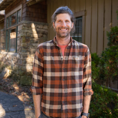 Faculty Member Eric Griffin stands smiling outside of Orr Cottage.