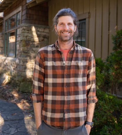 Faculty Member Eric Griffin stands smiling outside of Orr Cottage.