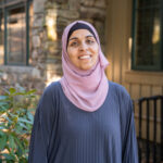 Faculty Member Nancy Matar stands smiling outside of Orr Cottage.