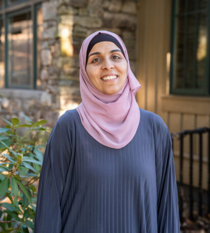 Faculty Member Nancy Matar stands smiling outside of Orr Cottage.