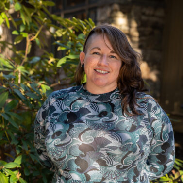 Faculty Member Scotti Norman stands smiling outside of Orr Cottage.