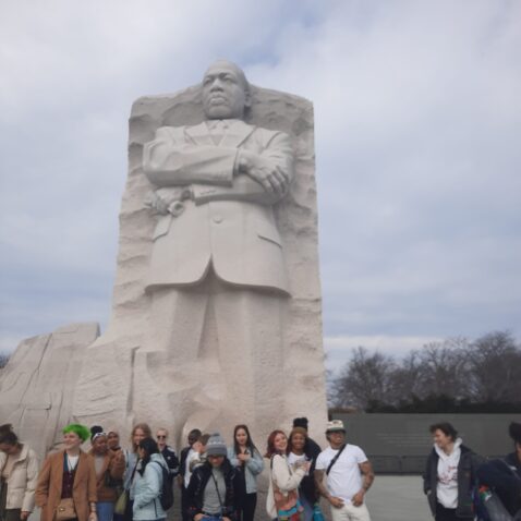 Engage Students in front of a stone statue of Dr. Martin Luther King Jr.