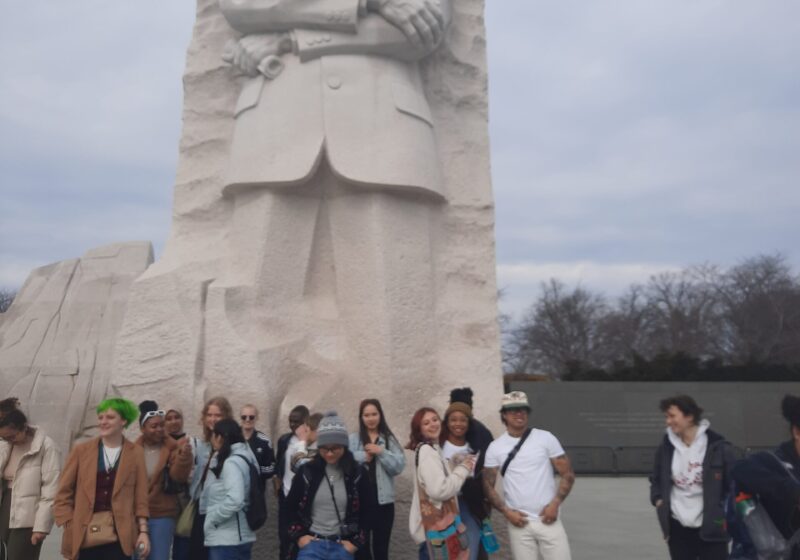 Engage Students in front of a stone statue of Dr. Martin Luther King Jr.
