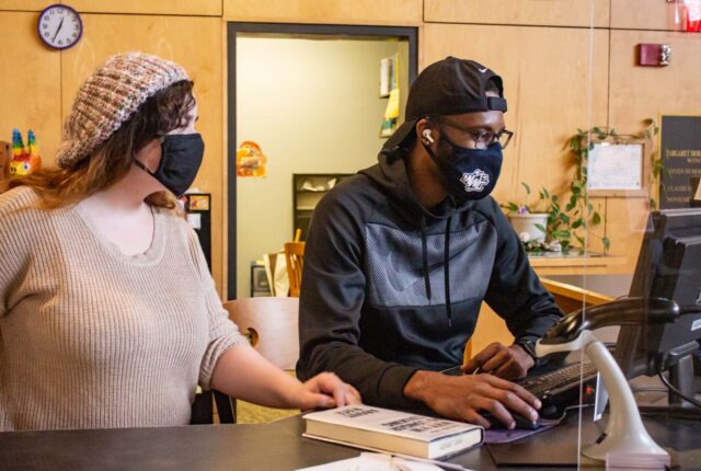 Library Crew students working at the circulation desk.