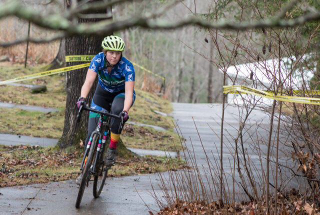 A student cycling wearing a Warren Wilson College Jersey