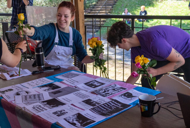 The Queer Resource Center Crew handing out flowers on Work Day.