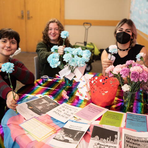 The Queer Resource Center Crew handing out flowers for Trans Remembrance day