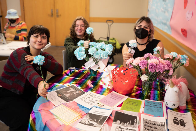 The Queer Resource Center Crew handing out flowers for Trans Remembrance day