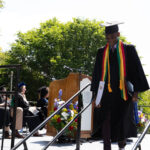 A Graduate walks down from the stage after receiving their degree