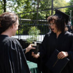 Anna Welton presents a tree to a graduate. The Graduate looks visibly excited.