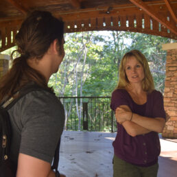 Faculty member Christine Swoap talks to a student in the pavillion.