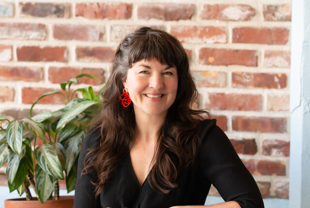 Jael Skeffington, co-founder and CEO of French Broad Chocolates, sitting with chocolates