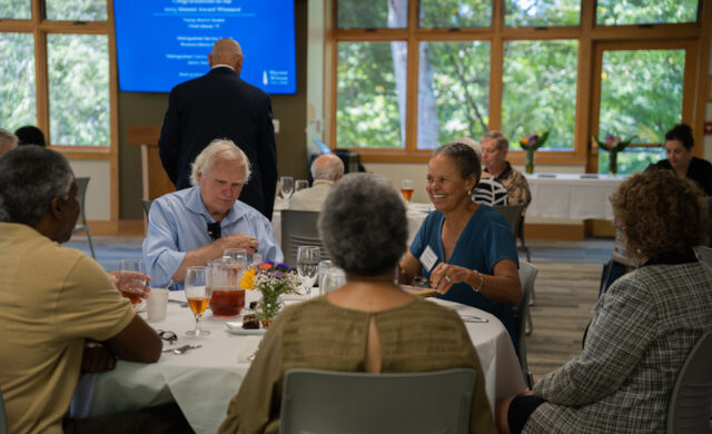 A group of alumni eat and talk with one another at the alumni award ceremony