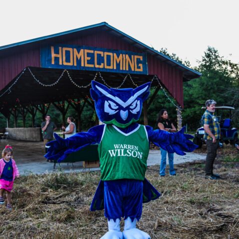 The owl mascot stands in front of the homecoming barn