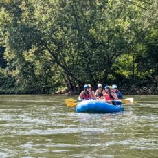 Students in a raft paddling down a river.