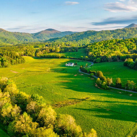 An aerial photo of the white barn and pastures