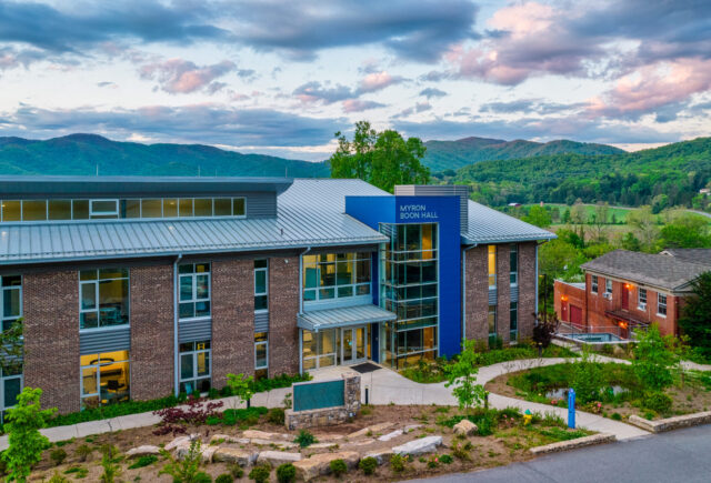 An aerial photo of Myron Boon Hall. A beautiful mountain vista can be seen in the background