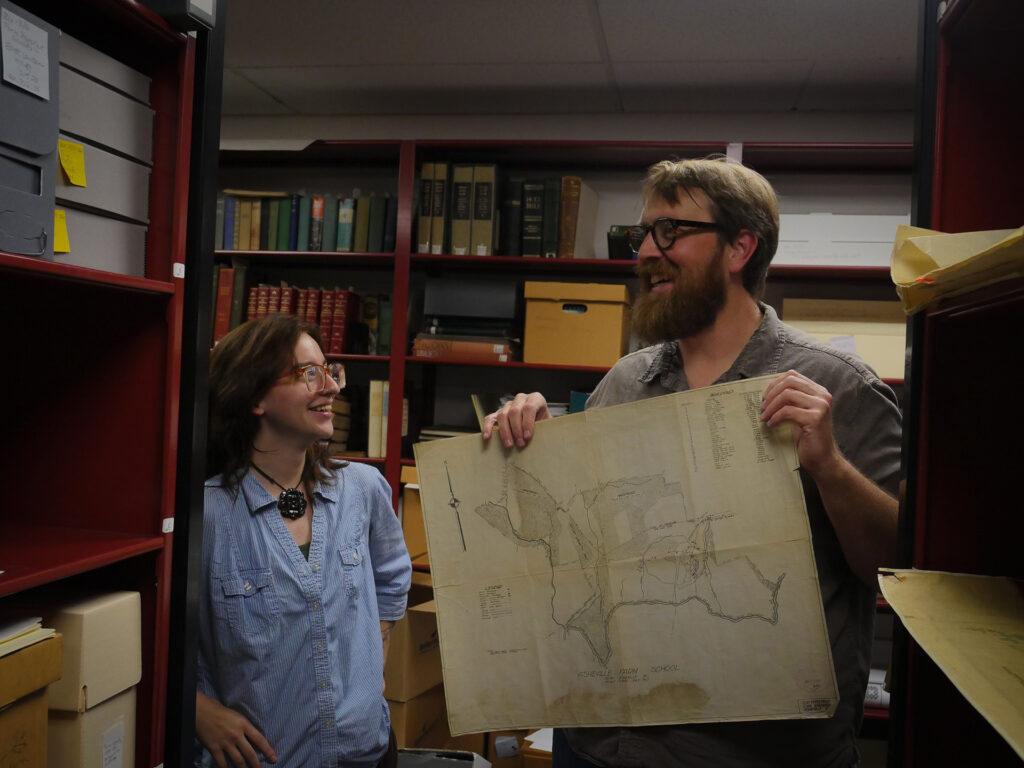 Dr. Jeff Keith works with a library archives student.