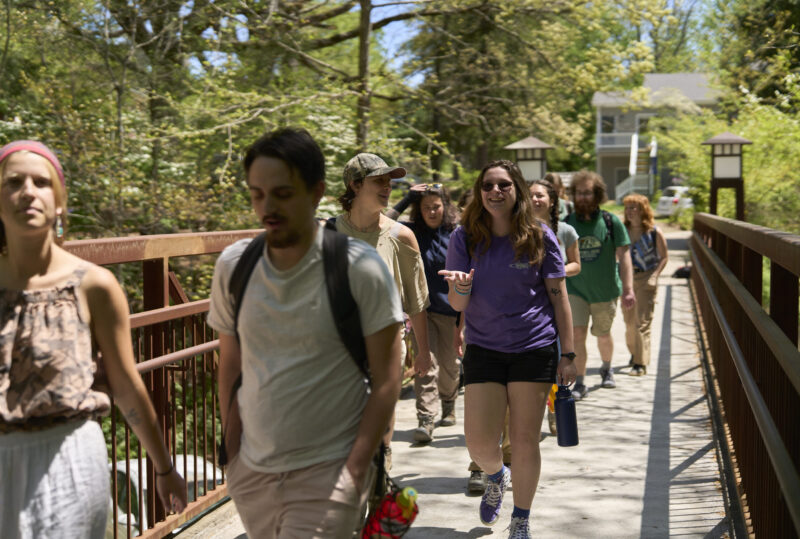 A group of students walk across the pedestrian bridge