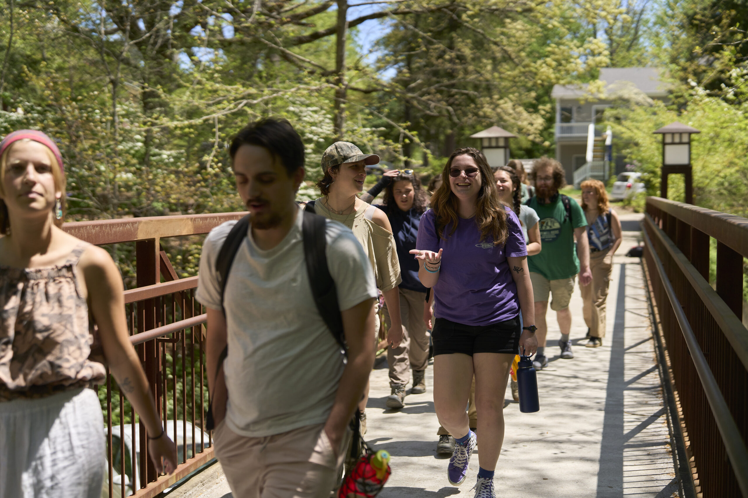 A group of students walk across the pedestrian bridge