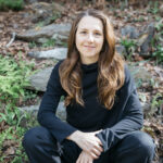 WWC Professor Ashley Cooper sits outside posed for a photo.