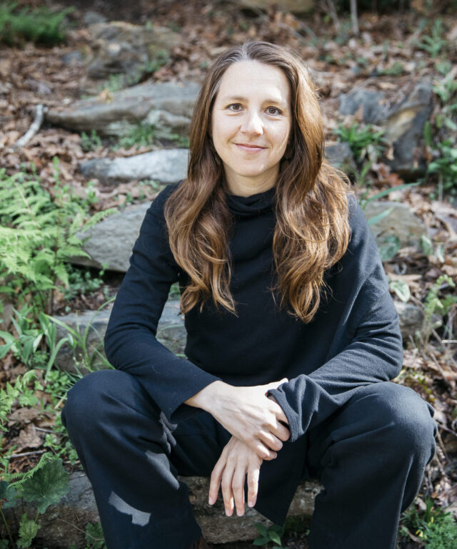 WWC Professor Ashley Cooper sits outside posed for a photo.