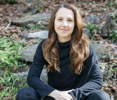 WWC Professor Ashley Cooper sits outside posed for a photo.