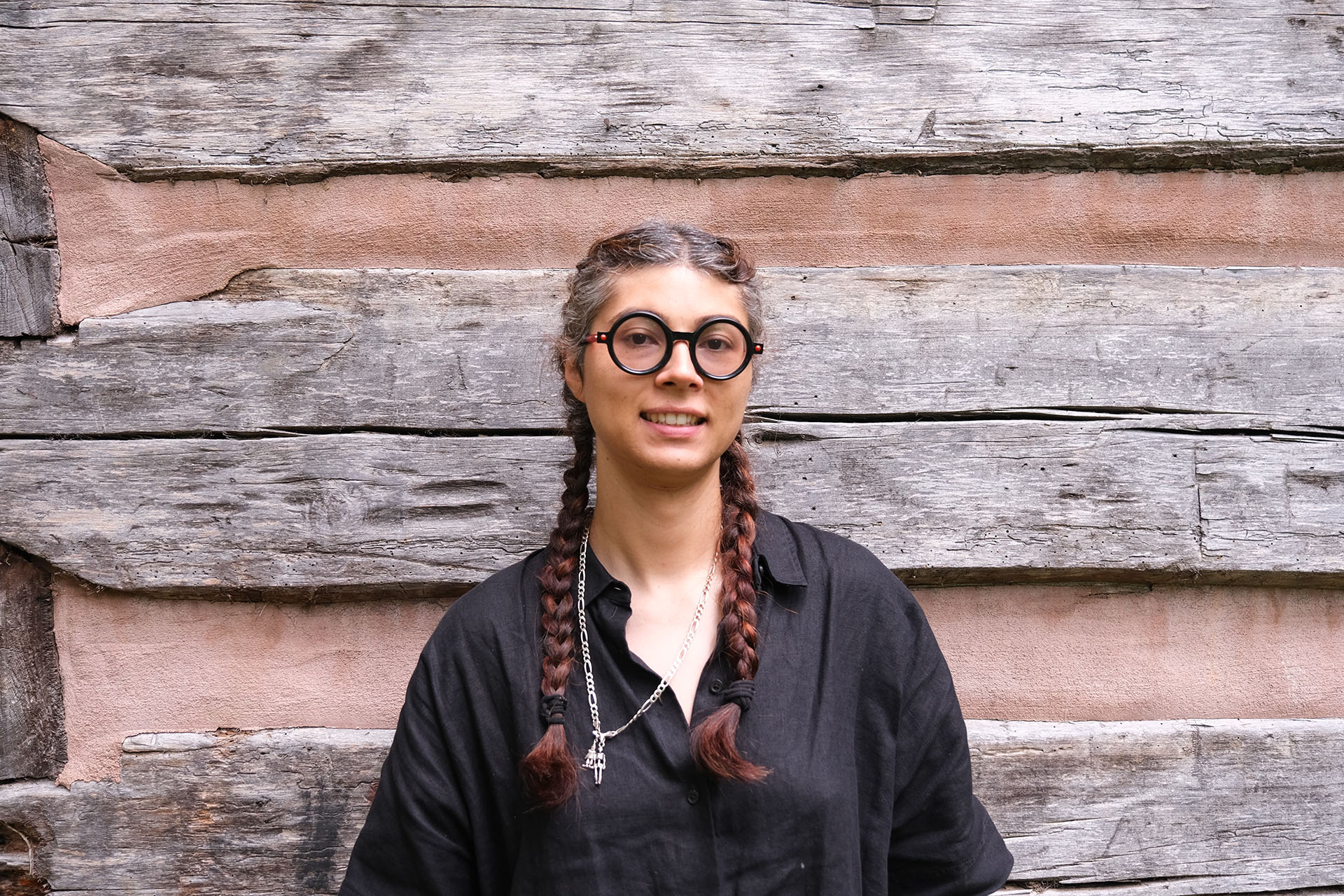 WWC Faculty Member Cris Culton stands in front of a wood backdrop.