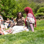 Students sit and talk with one another during lunch time outside.