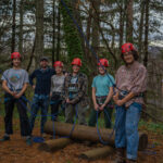 Students stand at the base of the alpine tower on campus
