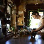 A Herb Crew student uses a mortar and pestle to grind some herbs in the herb cabin.