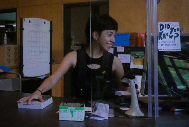 A student on the Library circulation crew checks in books.