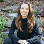 WWC Professor Ashley Cooper sits outside posed for a photo.