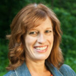 Dr. Melissa Booth stands smiling for a headshot photo.