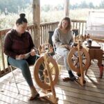 Fiber Arts Instructor Melanie Wilder teaches a student on the porch of the fiber arts cabin