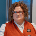 WWC professor of social work Dr. Lucy Lawrence sits and smiles directly at the camera.