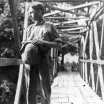 Archival photo of Asheville Farm School boy on a bridge