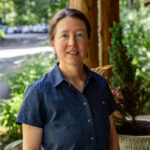 Visiting Assistant Professor of Outdoor Leadership, Priscilla D. Hunt, stands and looks at the camera for a picture in front of the WWC Admissions office.